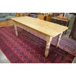 A pine farmhouse kitchen dining table, with rectangular top on a plain frieze raised on turned