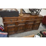 An Old Charm dark oak sideboard with four drawers over floral and linenfold carved panelled cupboard