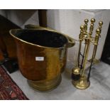 A planished brass coal bucket and a brass fireside companion set
