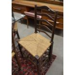 A harlequin set of eight provincial oak ladder back and rush seated dining chairs