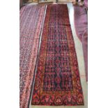 A Persian Kordi runner with repeating design on navy ground within palmette border, 380 x 90 cm