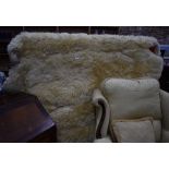 A large shaped cream sheepskin rug