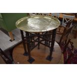 A Persian brass tray on folding hardwood stand