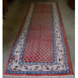 A Persian Hamadan rug, the central reserve filled with floral repeating boteh on red ground, ivory