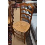 A set of four French wavy ladder-back dining chairs with rush seats