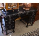 An ebonised kneehole desk with eleven drawers around a central niche, raised on turned supports