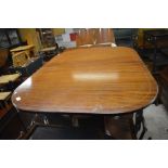 A mahogany cross banded pedestal dining table