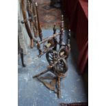 An antique stained fruitwood spinning wheel with twin spools