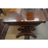 A Regency mahogany card table with folding baize-lined top raised on a turned and carved column