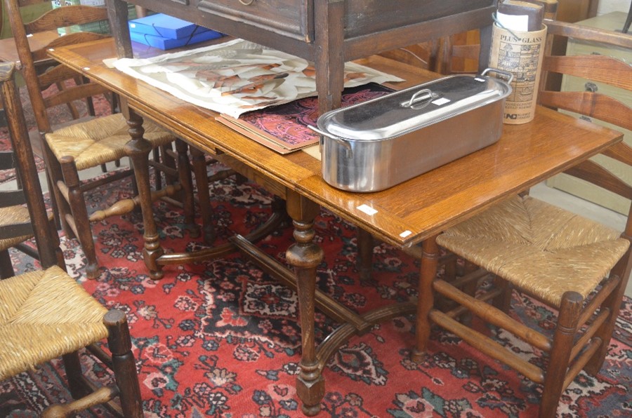 An oak extending dining table with panelled cleated draw-leaf top raised on slender turned