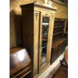 An antique stripped and waxed pine single mirror door wardrobe