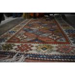 A small Turkish rug, the geometric design on terracotta ground with ivory border