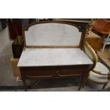 An Edwardian marble top wash stand with a pair of panelled doors, raised on turned and further