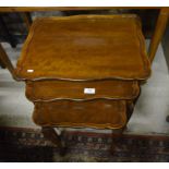 A nest of three walnut tables with carved pad footed cabriole supports