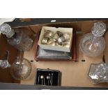 A mixed box to include four glass decanters, collection of napkin ring including a silver example,