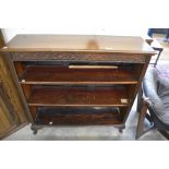 A mahogany open bookcase with two adjustable shelves, raised on short carved cabriole supports