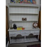 A distressed white painted pine dresser, the plate rack with two shelves on a base with six drawers,