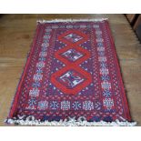 A small Persian Turkoman rug, the central diamond medallions on red ground, repeating border, 88 x