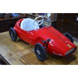 A Triang Ferrari pedal car with white vinyl seat,