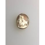 An oval shell cameo brooch carved with two putti seated on a hound