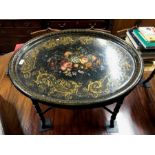 A Victorian oval gilt and polychrome decorated ebonised papier mache tray