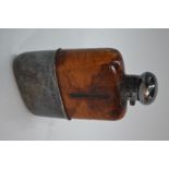 A leather-clad glass hip-flask with silver bun cover