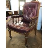 A Victorian oak framed buttoned red leather library armchair