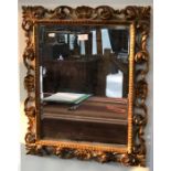 An antique Florentine style giltwood framed bevel edged mirror