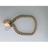 A 9ct rose gold curb chain with padlock and safety chain