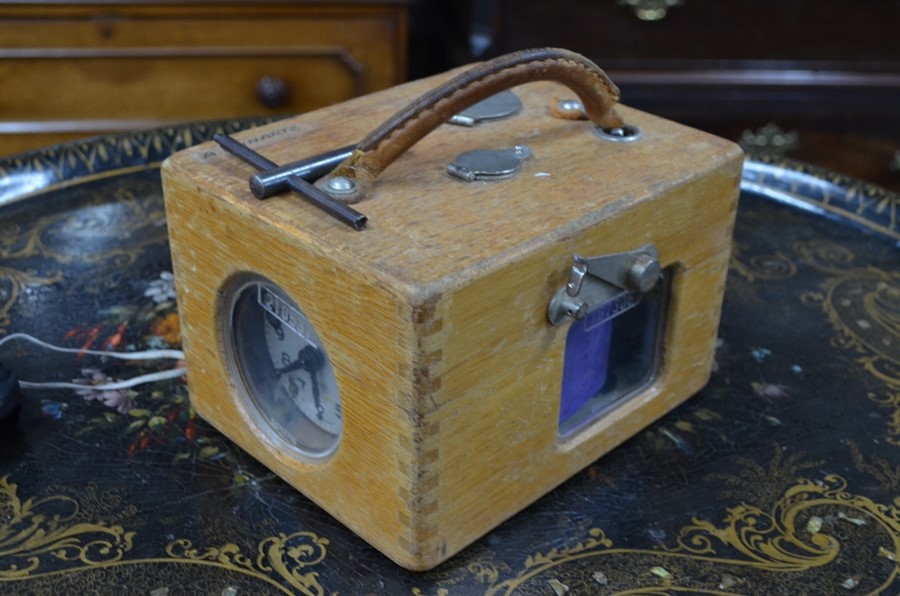 A vintage German racing pigeon timing clock in oak case