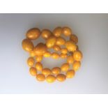 A row of honey-coloured oval graduated amber beads