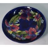A large Moorcroft shallow bowl decorated in the 'Slipper Orchid' pattern