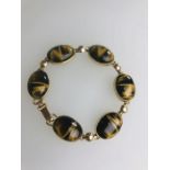 A bracelet formed of six oval cabochon tiger's eyes,