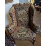 An antique walnut framed wingback armchair