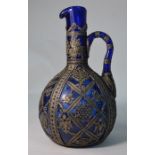 A large 19th century continental blue glass ewer with white metal overlay decoration