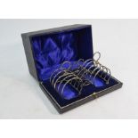 A cased pair of silver four-division wire toast racks etc.