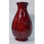 A large William Moorcroft sang de beouf/flambe baluster vase