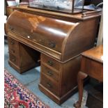 An antique walnut cylinder top kneehole desk