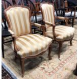 A pair of Louis XV style salon armchairs, with yellow/gold fabric overstuffed seat and back panel