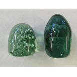 Two green glass 'Dump' paperweights.