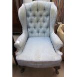 A 19th century wing back chair with a blue damask upholstery on leaf capped cabriole legs