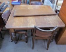 An Edwardian oak extending dining table and four chairs