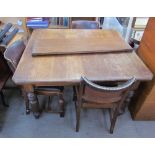 An Edwardian oak extending dining table and four chairs