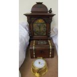 An oak mantle clock with a domed top above a silvered dial with Roman numerals,
