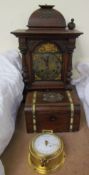 An oak mantle clock with a domed top above a silvered dial with Roman numerals,