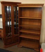 A modern oak standing corner with glazed doors together with a matching bookcase