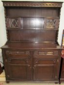 A 20th century oak dresser with cupboards and shelves to the rack,