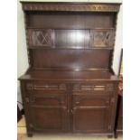 A 20th century oak dresser with cupboards and shelves to the rack,