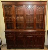A reproduction mahogany bookcase, the moulded dentil cornice above four glazed doors,