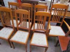 A set of seven oak dining chairs, with spindle back and pad seat on square tapering legs,